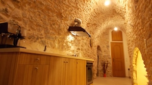 A kitchen with stone walls, wooden cabinets, and a built-in oven.