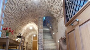 A stone-walled interior with a staircase leading to a door.