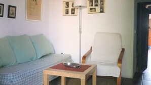 A room with a checkered sofa, a white armchair, a small wooden table with a metal bowl, and a floor lamp. - Casa Ábalos, in the middle of nature (Periana)