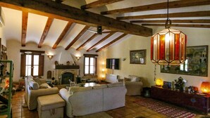 A cozy living room with a fireplace, wooden beams, and a hanging lantern. - Five stars reviews - Peaceful - Fantastic pool - Privacy & Long views (Jávea)