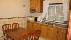 Una cucina con mobili in legno, un piano di lavoro in granito e una finestra con tende.