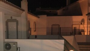 Un edificio con diverse porte e finestre, una scala e un condizionatore d'aria fissato al muro.
