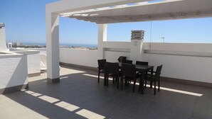 A rooftop terrace with a table and chairs, a pergola, and a view of the city and sea. - Holiday Houses - Los Altos 92 (Torrevieja)