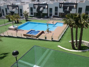 A modern pool area with a rectangular pool, surrounded by artificial grass and palm trees. - Holiday Houses - Los Altos 92 (Torrevieja)