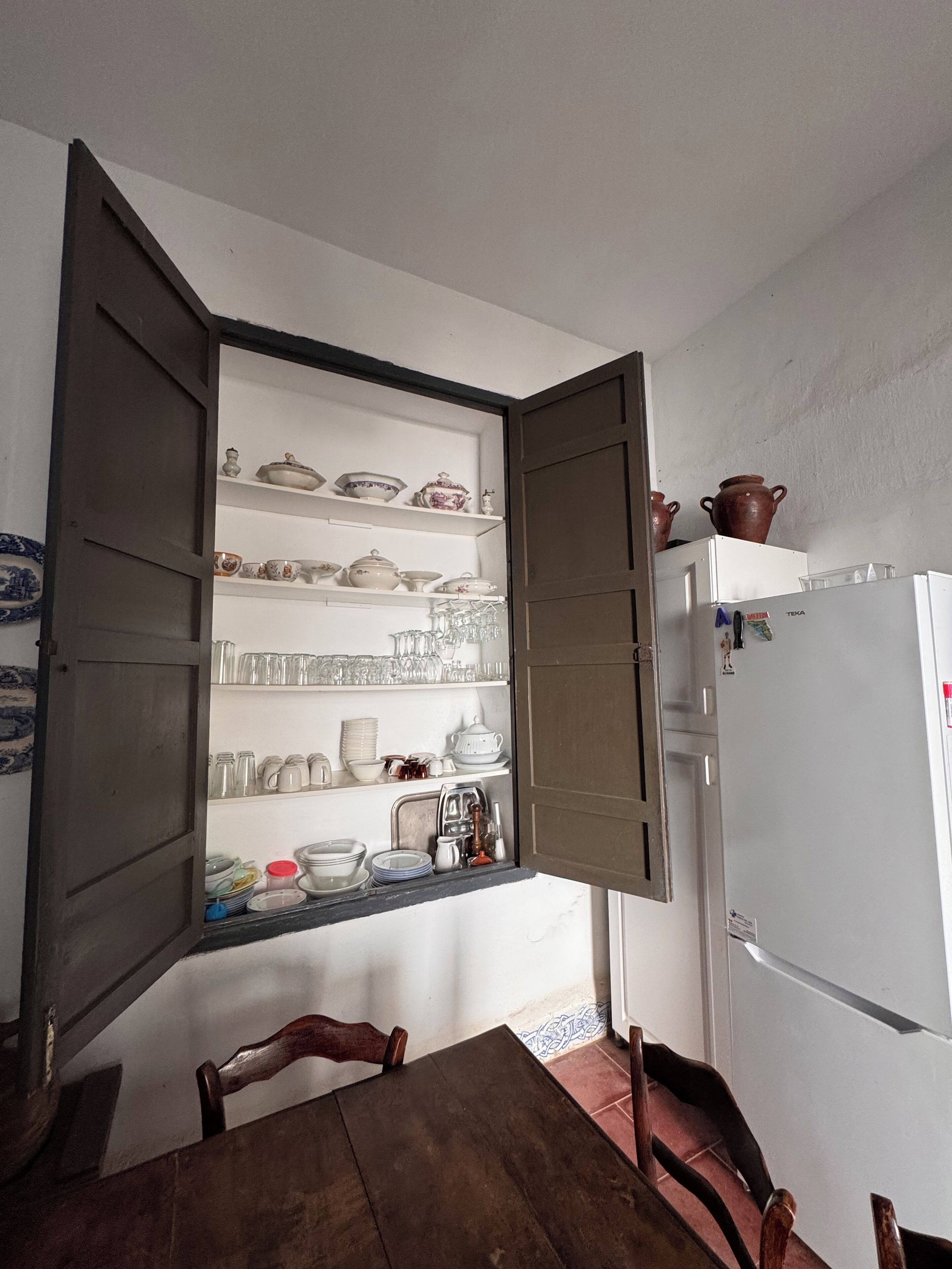 Une cuisine avec des placards ouverts où sont exposées la vaisselle et les verres.