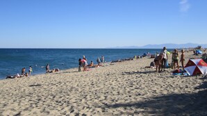 A beach with people sunbathing and swimming. - For rent T2- Leucate plage - 1er D- Front de mer (Leucate)
