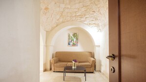 A room with a beige sofa, a coffee table, and a painting on the wall.