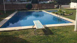 A rectangular swimming pool with a sun lounger and a ladder.