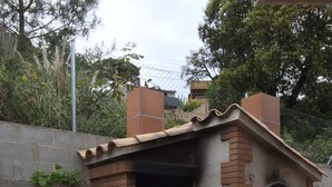 A brick-built outdoor kitchen with a chimney, a pizza oven, and a bag of flour. - Fantastic House with Private Pool in Lloret de Mar (Vidreres)