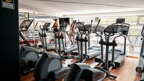 Ett gym med löpband och crosstrainers, stora fönster och en skylt som anger en maximal användningstid på 30 minuter.
