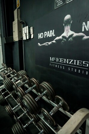 A gym with dumbbells and a poster on the wall.