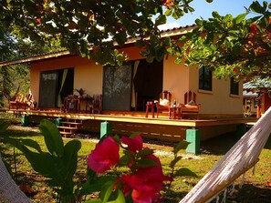 A house with a wooden deck, large windows, and a hammock. - Fidelito Ranch & Lodge (Paquera)