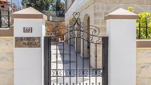 A gated entrance with a stone wall and a metal gate.