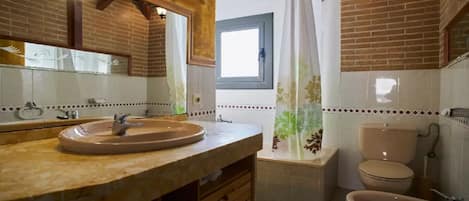 Bañera con ducha, bidet, toallas, shampoo