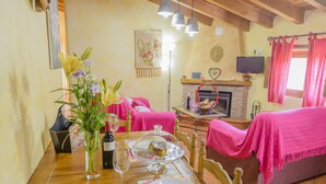 A dining table set with plates, a wine bottle, and a vase of flowers. - RURAL HOUSE "TENGUERENGUE" (Laroya, Almería)