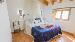 A bedroom with a bed under a canopy, a window with wooden shutters, and a tiled floor. - RURAL HOUSE "TENGUERENGUE" (Laroya, Almería)