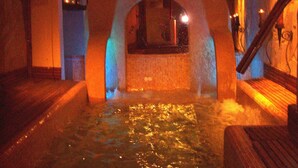 A spa area with a hot tub, wooden flooring, and a stone archway. - Rural Suite with Jacuzzi in Alcaraz (For 2 people) (Alcaraz)