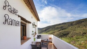 A balcony with a table and chairs, a potted plant, and a sign reading "Padre Ramon". - Rural house (rental entire) Reul Alto Cortijos Rurales for 2 people (Laroya)