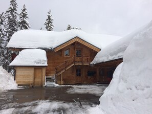 A wooden lodge with a covered entrance and a staircase leading to a balcony. - Les Saisies, Chalet Carons 6 - 4 pers. 3 *. Great comfort. La forêt sector (Villard-Sur-Doron)