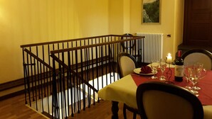 A dining area with a table set for two, a candle, and a bottle of wine. - Castello Izzalini Todi Resort "Apt 4" (Izzalini)