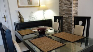 A dining table with a glass top, two chairs, and a decorative bowl. - Luxury Aptmt, Seaview Sunset, Large Pool, free Wi-Fi, UK-TV (Peyia)