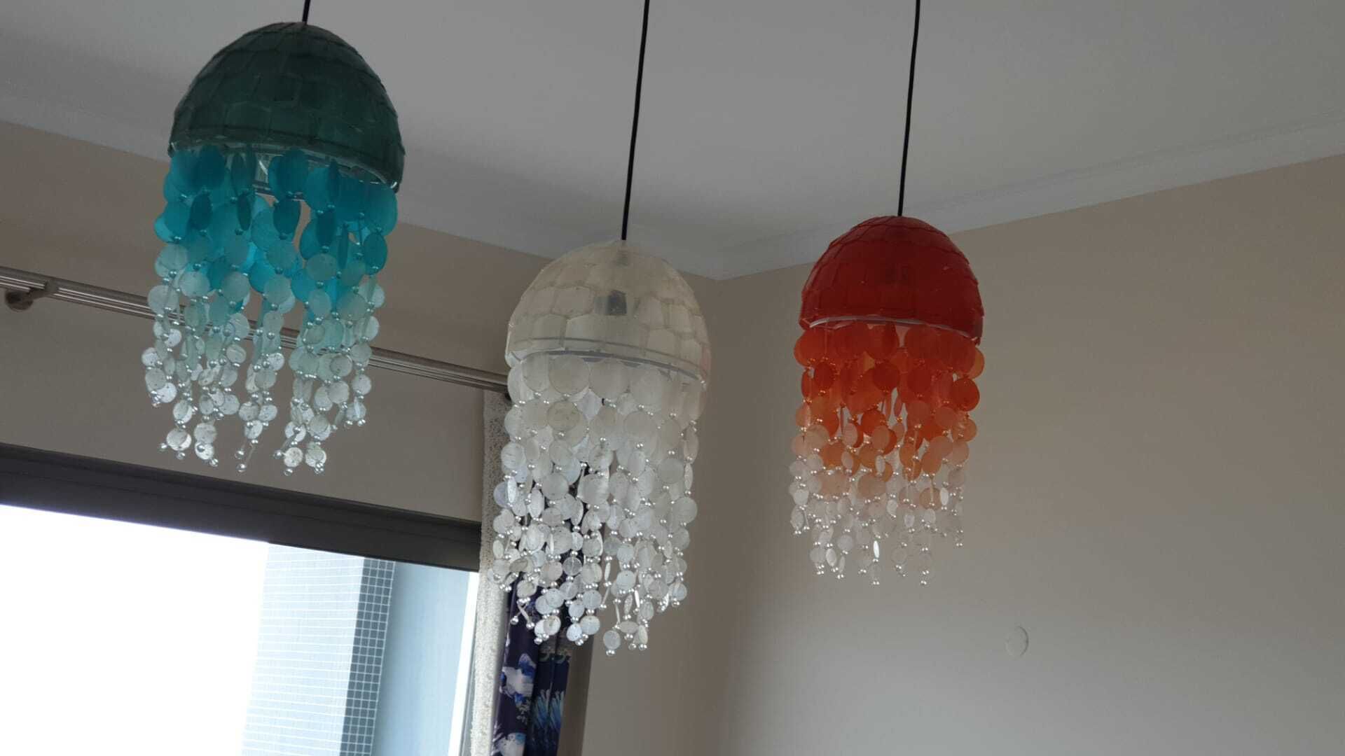 Drei Pendelleuchten mit kristallartigen Verzierungen hängen von der Decke.