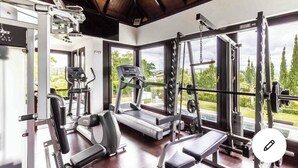 Et fitnesscenter med løbebånd, træningsudstyr og konditionsmaskiner.