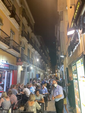 A narrow street lined with buildings, some with balconies and outdoor seating areas. - Boutique Apartment by the Sea (Alicante)