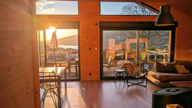 A cozy cabin interior with a dining area, a sofa, and a fireplace. - L' Edelweiss, luxury chalet with exceptional lake view, close to center/slopes (Gérardmer)