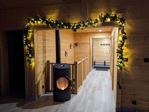 Un corridoio con una stufa a legna, pareti in legno e una ghirlanda di luci.
