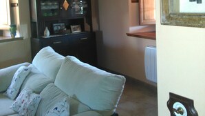 Une pièce comprenant un canapé, une armoire et une clé encadrée accrochée au mur.