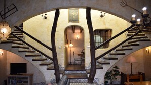 A grand staircase with a stone base and wooden railings, leading to a dining area with a table and chairs. - Finca Almencino with private pool for 6 people, fantastic sea views (Cómpeta)