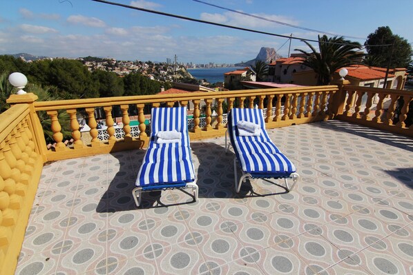 Two sun loungers on a tiled balcony with a view of a coastal cityscape. - MARYVILLA0224-Wifi y Parking Gratis-Cerca Playa (Calpe)