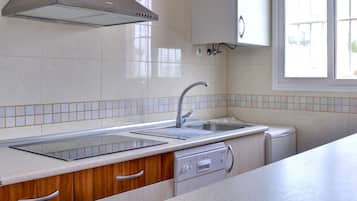 Een koelkast, een magnetron, een kookplaat, een vaatwasser