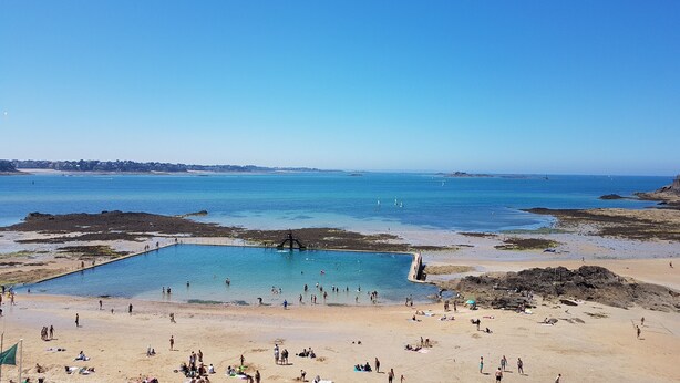 A beach with a clear blue sky, a swimming pool, and people enjoying the beach. - Apartment/ flat - Saint-Malo (Saint-Malo)