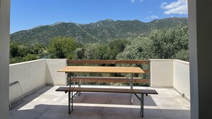 A balcony with a wooden bench and a view of mountains. - Holiday house " Katy" on Bacina Lakes (PLOCE, PERACKO BLATO)