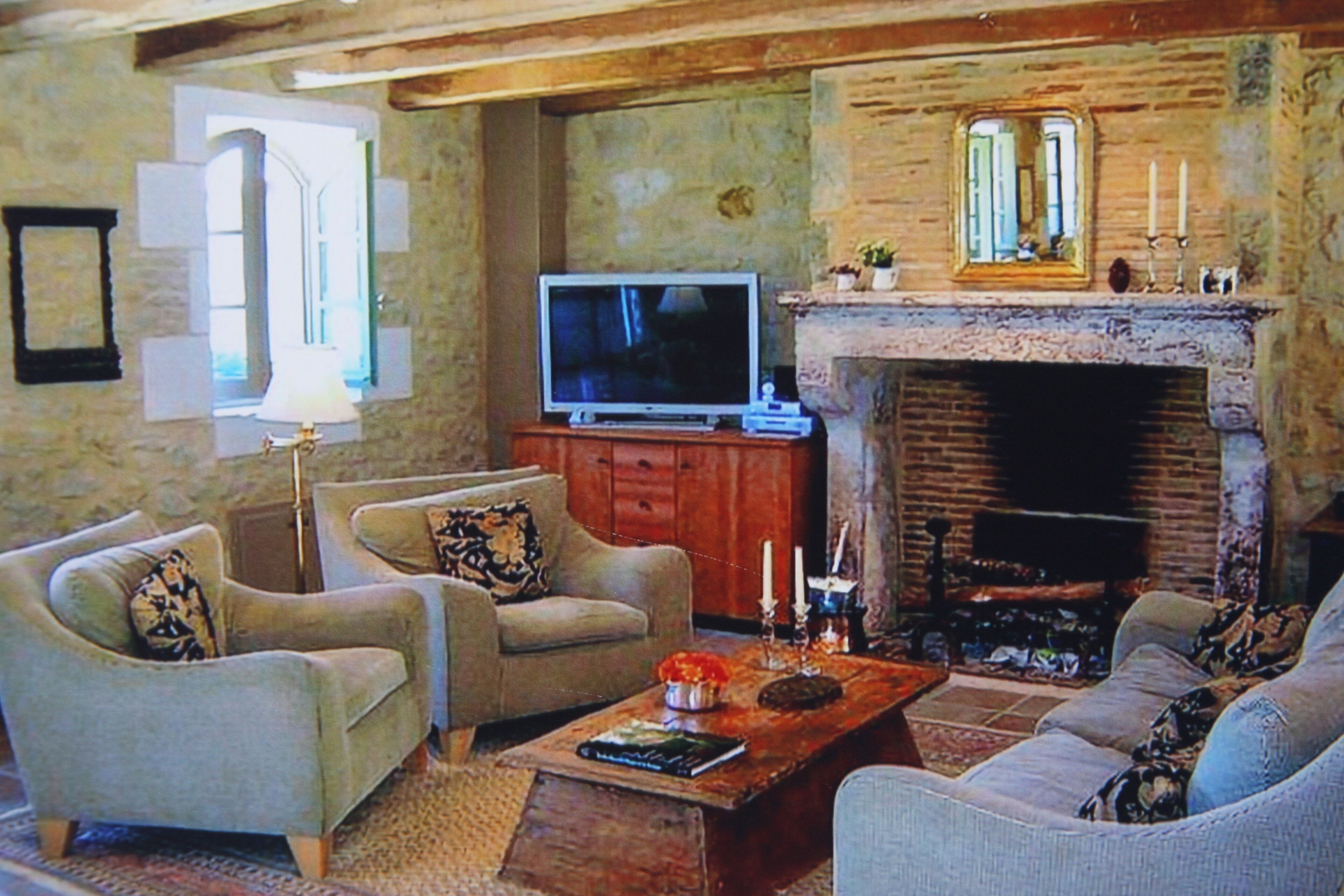Ein Wohnzimmer mit zwei Sofas, einem Couchtisch, einem Fernseher und einem Kamin.