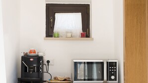 A compact kitchenette with a coffee maker, microwave, and refrigerator. - magic and charm in a trullo  (Noci)