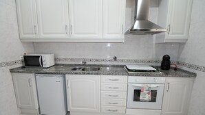 A kitchen with white cabinets, a microwave, a dishwasher, a stove, and a sink. - Sete Rios, Near Zoo Lisboa/ free Wifi (Lisboa)