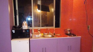 A small kitchen with a window, a microwave, a sink, and cabinets.