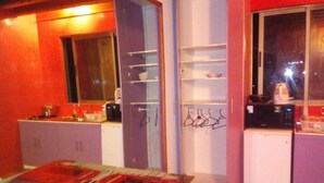 A compact kitchen with a dining table, a microwave, and a refrigerator.