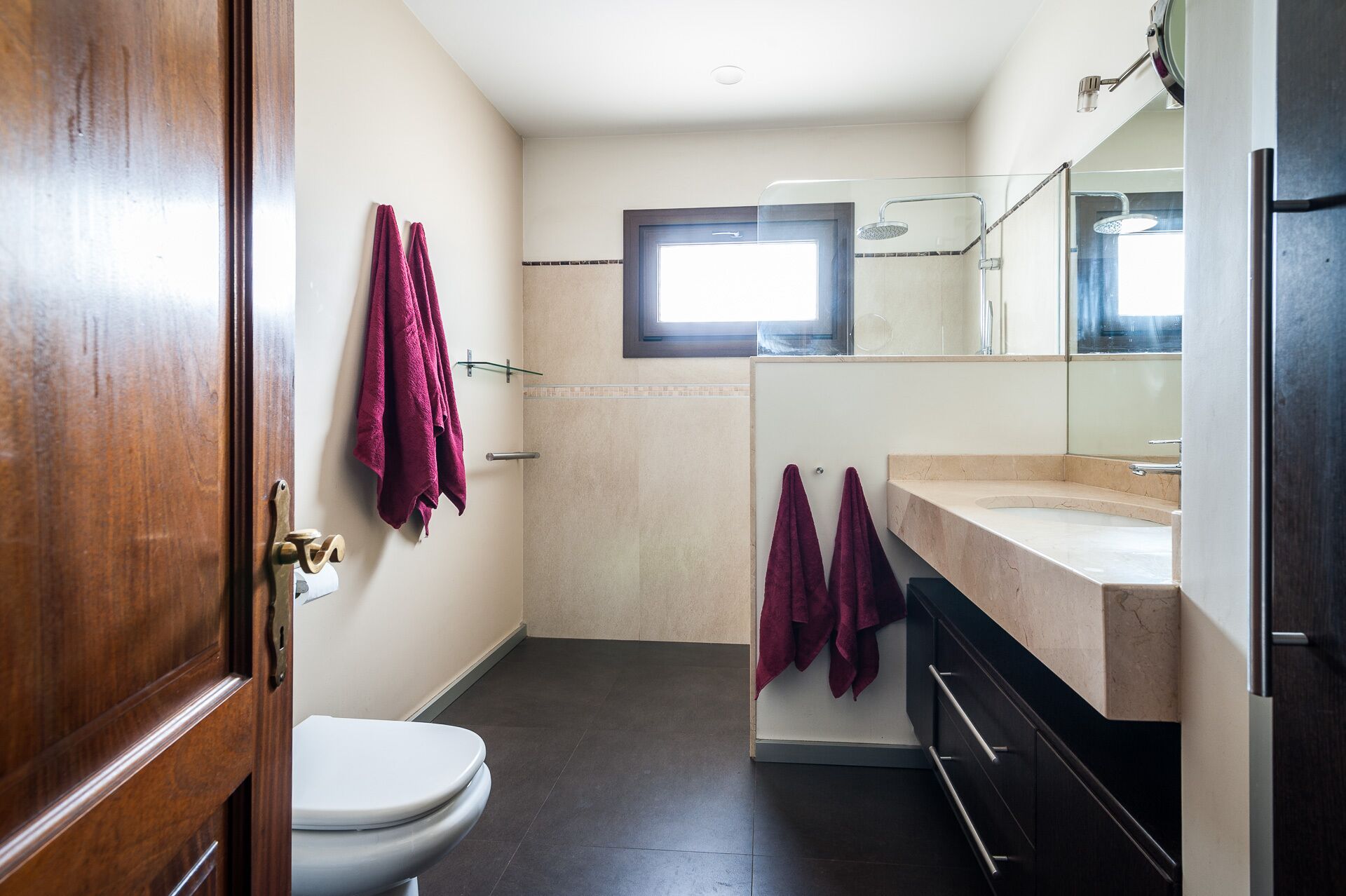 A bathroom with a toilet, a sink, and a shower area.