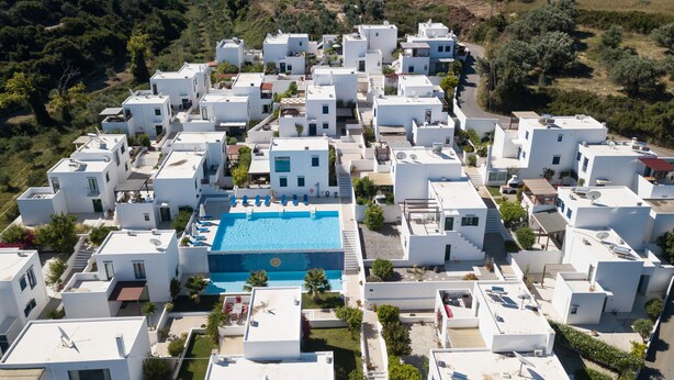 A residential area with white buildings, a central swimming pool, and surrounding greenery. - Island-style 3 bedroom house!  (Rethymno)