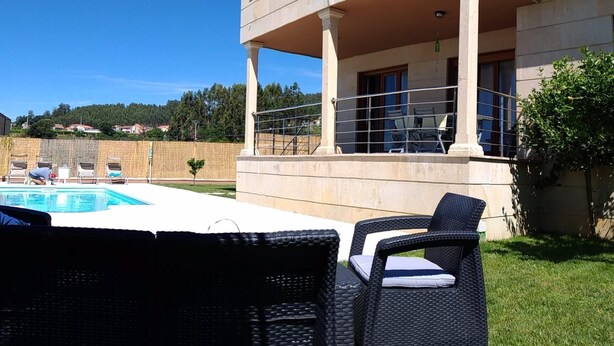 A two-story building with a pool and outdoor seating. - Beach, valley and relaxation (Pontevedra)