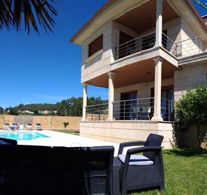 A two-story building with a pool and outdoor seating. - Beach, valley and relaxation (Pontevedra)