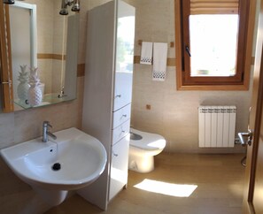 A bathroom with a sink, toilet, and a window. - Beach, valley and relaxation (Pontevedra)