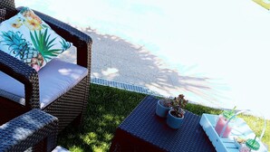 An outdoor patio area with wicker furniture, a pool, and a view of the surrounding landscape. - Beach, valley and relaxation (Pontevedra)
