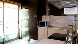 A modern kitchen with a microwave, toaster, and a built-in oven.
