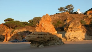 A coastal landscape with rock formations and a clear sky.