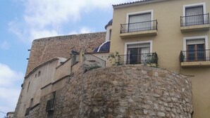 A stone wall with a clock tower and a building with balconies. - House very close to beach, family, quiet, clean, air cond., Bright and fresh (La Vila Joiosa/Villajoyosa)